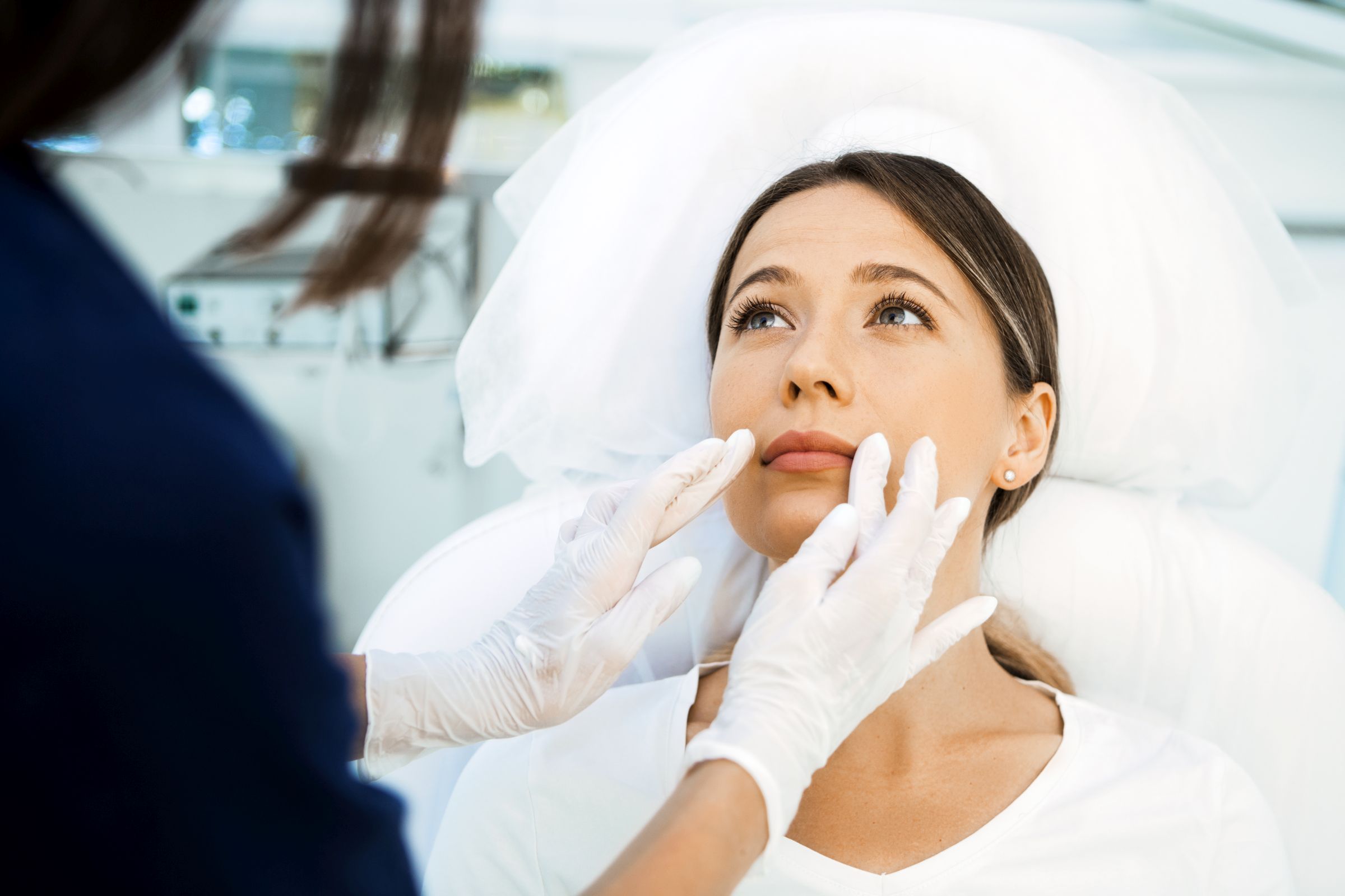 Cosmetologist preparing to doing cosmetic facial treatments for the young woman